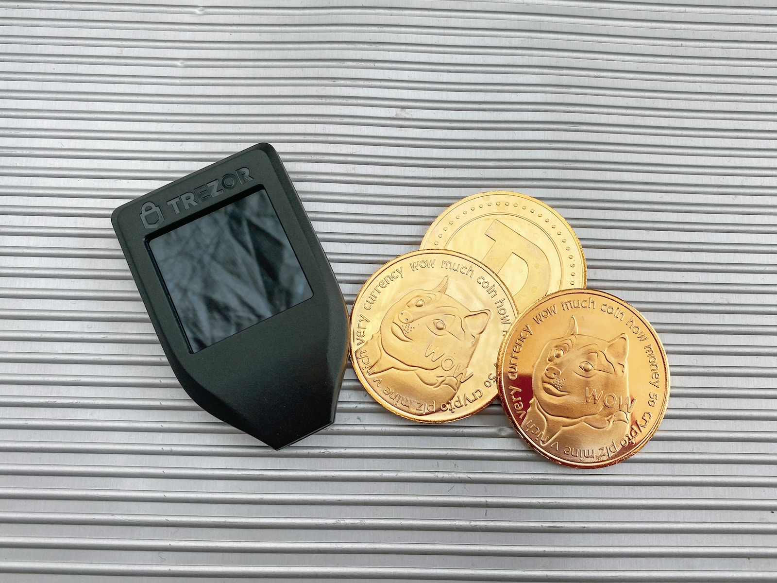 a digital camera next to a pile of gold coins